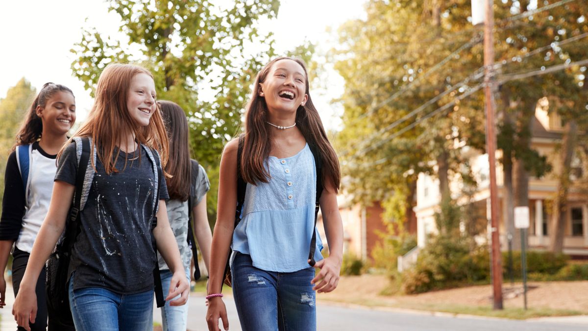 A group of teen friends laughing on the way to class